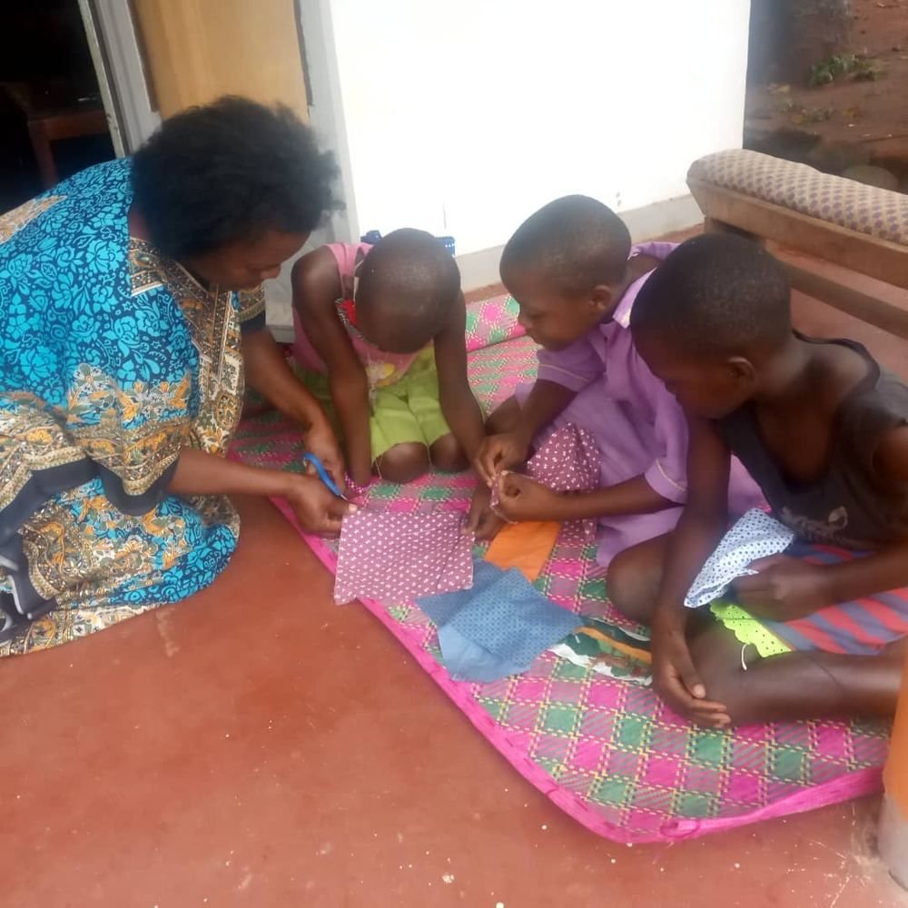 A mentor guiding young girls through a hands-on activity